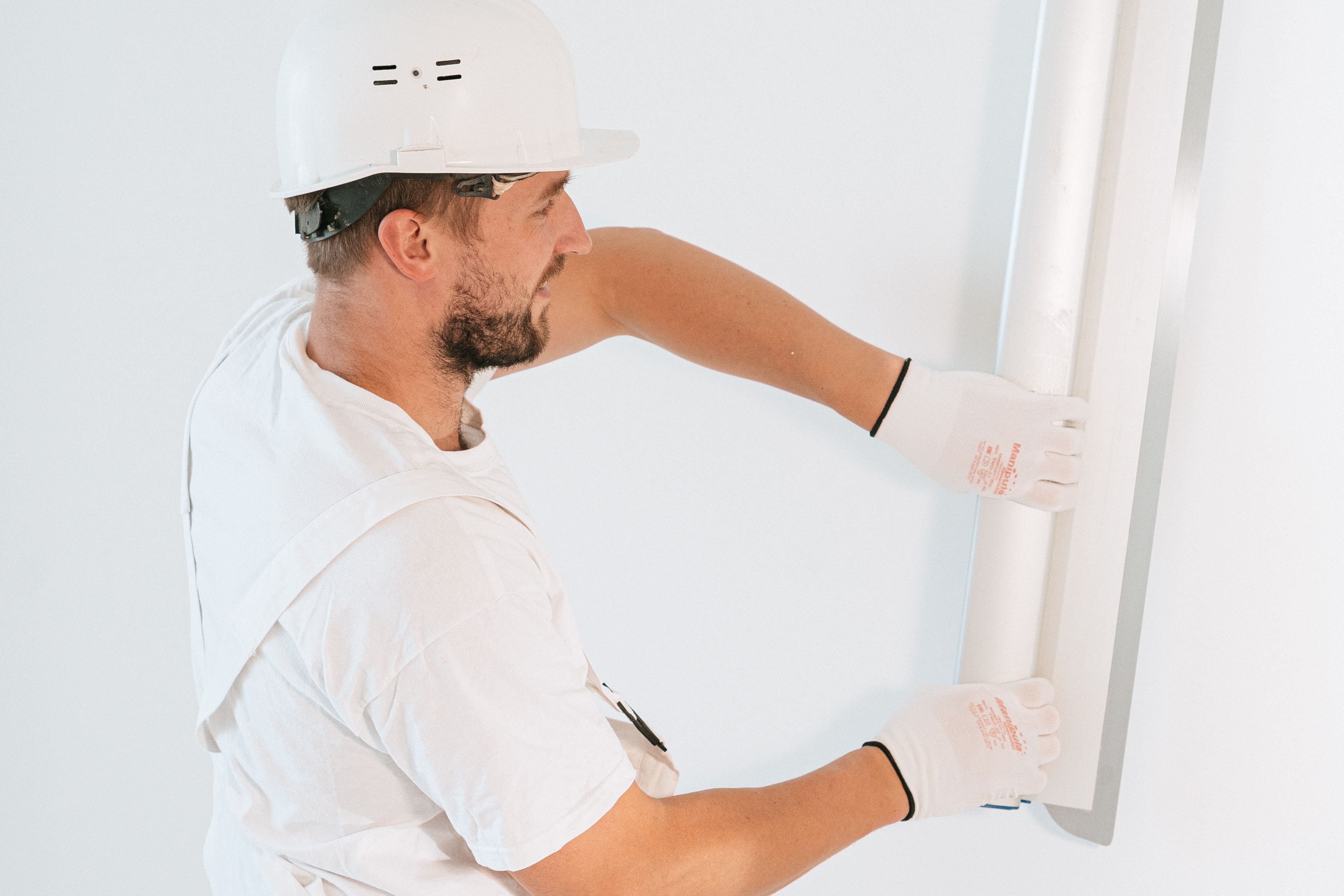 Contractor finishing drywall while rebuilding a water-damaged interior